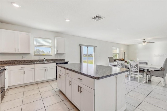 11476 Sage Canyon Dr, Riverview, FL 33578 - kitchen with a sink, dark countertops, visible vents, and light tile patterned floors