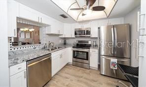 11720 Park Blvd Unit 301, Seminole, FL 33772 - kitchen with tasteful backsplash, a ceiling fan, light wood-style floors, white cabinetry, and stainless steel appliances