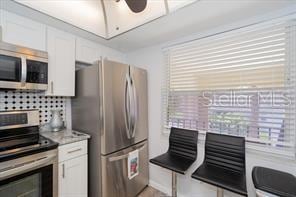 11720 Park Blvd Unit 301, Seminole, FL 33772 - kitchen with a ceiling fan, light countertops, white cabinetry, and stainless steel appliances