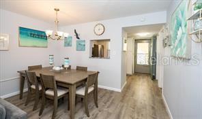 11720 Park Blvd Unit 301, Seminole, FL 33772 - dining area with wood finished floors, a notable chandelier, and baseboards