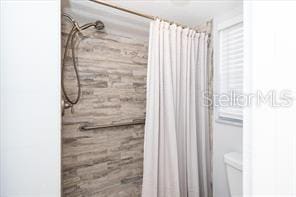11720 Park Blvd Unit 301, Seminole, FL 33772 - full bathroom featuring a shower with shower curtain and toilet