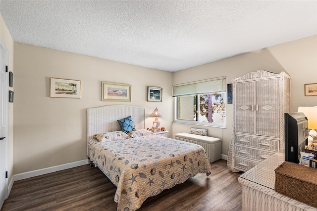 bedroom with baseboards, a textured ceiling, and dark wood-style floors