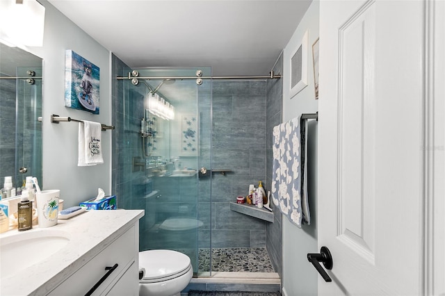 bathroom with visible vents, vanity, a shower stall, and toilet