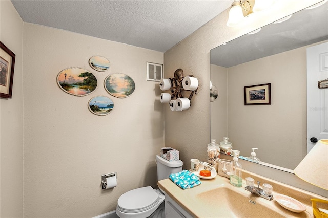 bathroom featuring a textured ceiling, visible vents, toilet, and vanity