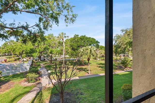view of home's community featuring a lawn and fence
