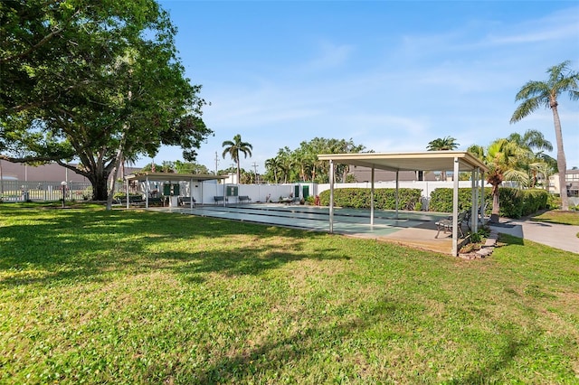view of home's community featuring a yard, shuffleboard, and fence