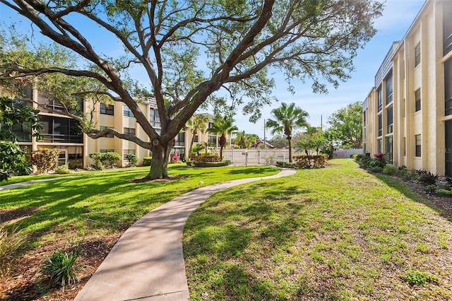view of property's community featuring fence and a yard