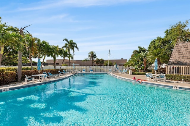 community pool with fence and a patio area