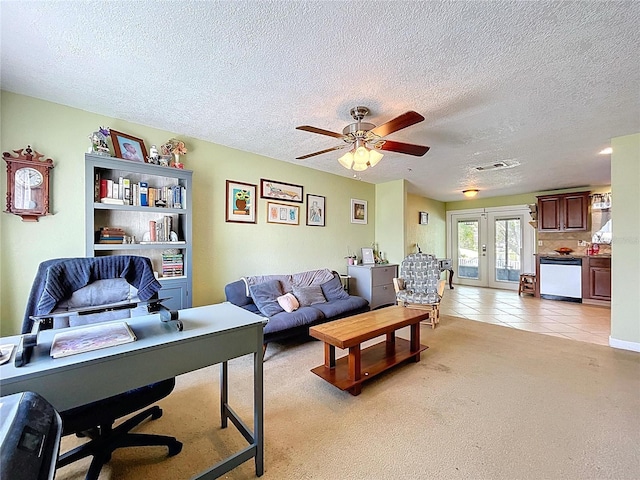 living area with visible vents, a textured ceiling, french doors, light tile patterned flooring, and light carpet