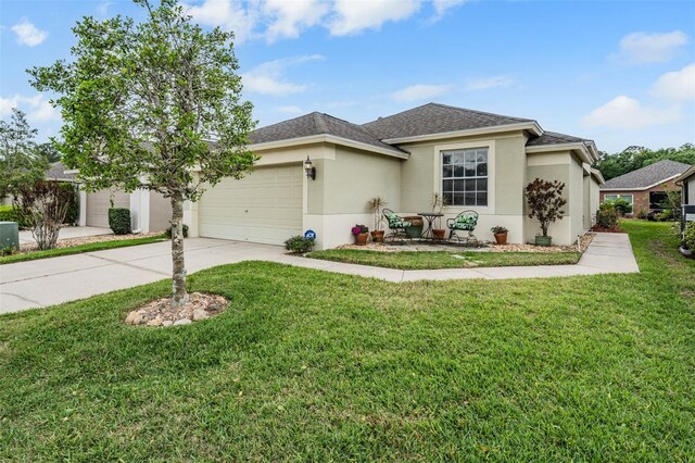 5116 Gato Del Sol Cir, Wesley Chapel, FL 33544 - view of front of home with a garage, stucco siding, driveway, a front lawn, and roof with shingles