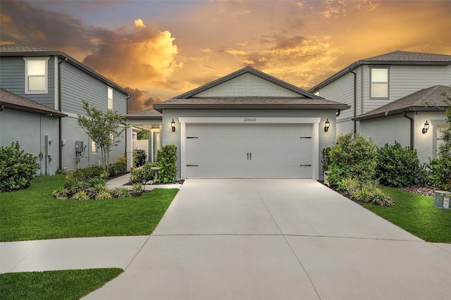 20659 Drake Elm Dr, Land O Lakes, FL 34638 - view of front of house featuring driveway, a front lawn, an attached garage, and stucco siding