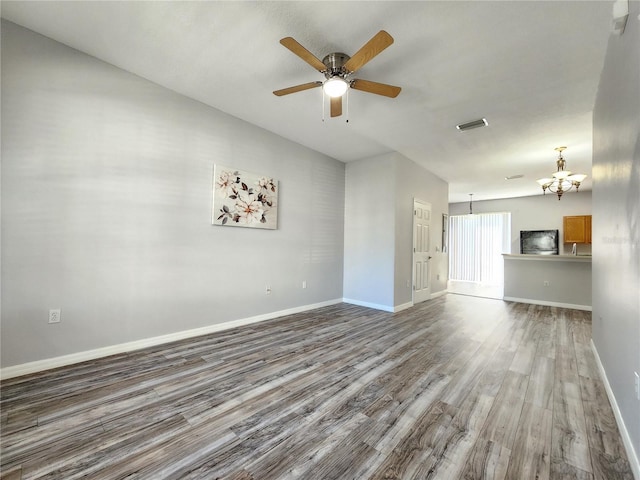 8796 Christie Dr, Largo, FL 33771 - unfurnished living room featuring wood finished floors, baseboards, a chandelier, and a ceiling fan