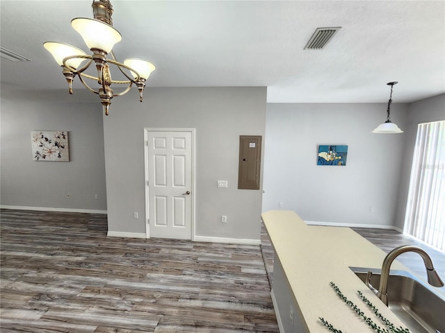 8796 Christie Dr, Largo, FL 33771 - kitchen featuring electric panel, dark wood-style flooring, baseboards, a sink, and hanging light fixtures