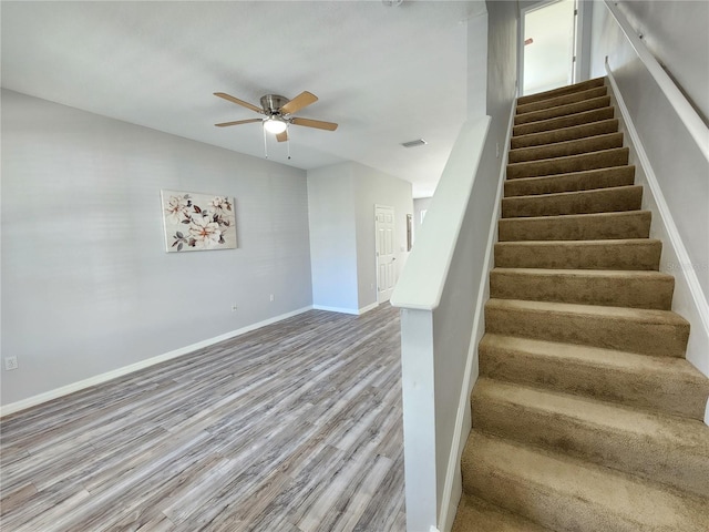 8796 Christie Dr, Largo, FL 33771 - stairway with a ceiling fan, wood finished floors, and baseboards