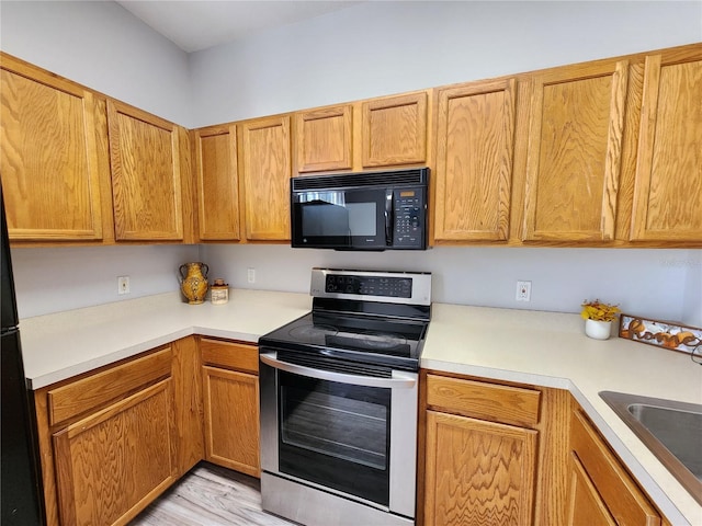 8796 Christie Dr, Largo, FL 33771 - kitchen featuring black microwave, stainless steel electric stove, light countertops, and a sink