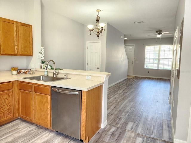8796 Christie Dr, Largo, FL 33771 - kitchen featuring stainless steel dishwasher, a sink, a peninsula, light wood-type flooring, and open floor plan