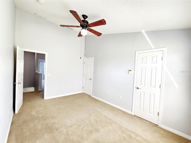 8796 Christie Dr, Largo, FL 33771 - unfurnished bedroom with light carpet, baseboards, high vaulted ceiling, and ceiling fan