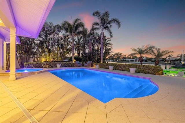 pool featuring a patio area and an in ground hot tub