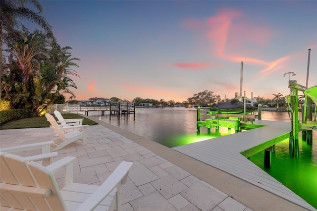 dock area featuring a water view, boat lift, and a patio area