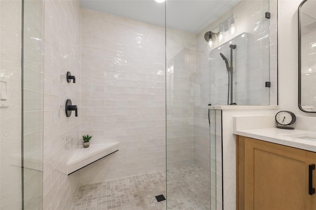 bathroom featuring tiled shower and vanity