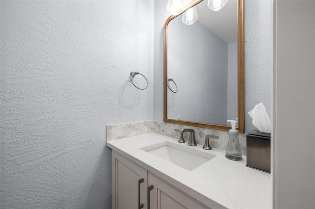 bathroom featuring vanity and a textured wall
