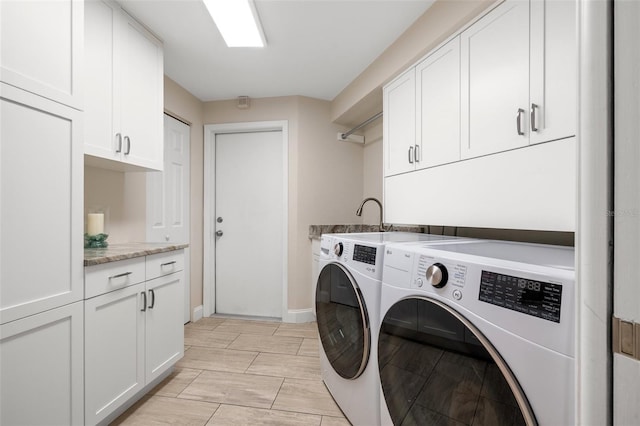 washroom with independent washer and dryer, baseboards, and cabinet space