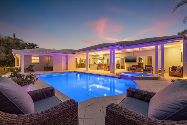 view of pool featuring a patio area, an outdoor living space, and a pool with connected hot tub