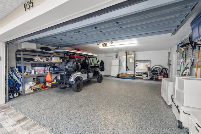 garage featuring freestanding refrigerator and a garage door opener