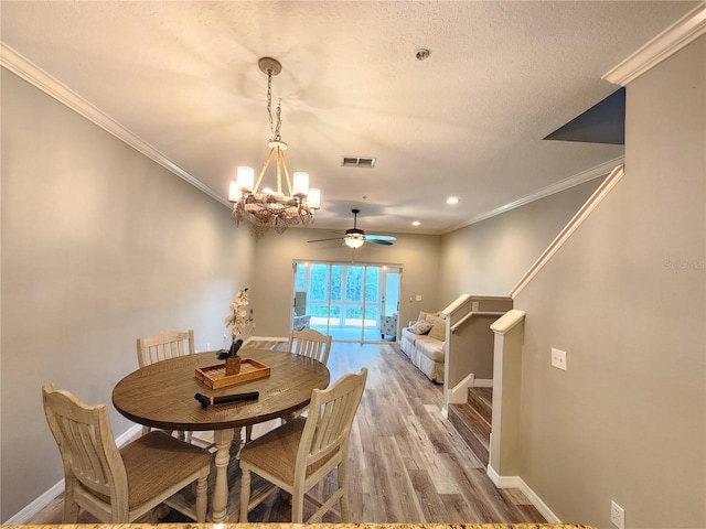 dining area with baseboards, ornamental molding, light wood-style floors, and visible vents