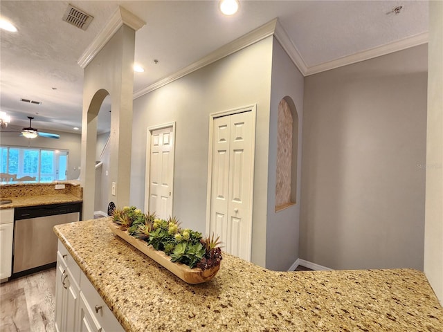 interior space featuring visible vents, stainless steel dishwasher, white cabinetry, and arched walkways