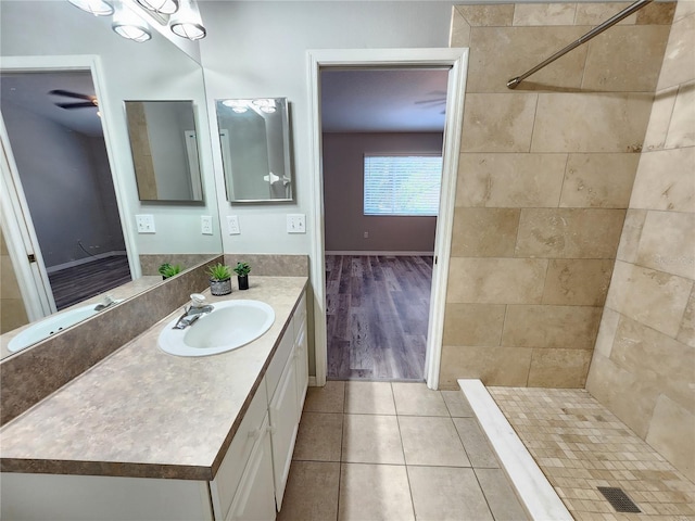 full bath featuring vanity, a tile shower, and tile patterned flooring
