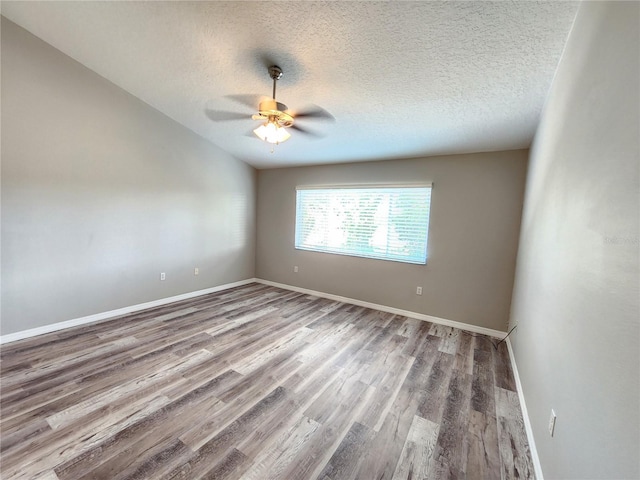 unfurnished room with baseboards, wood finished floors, a ceiling fan, and a textured ceiling