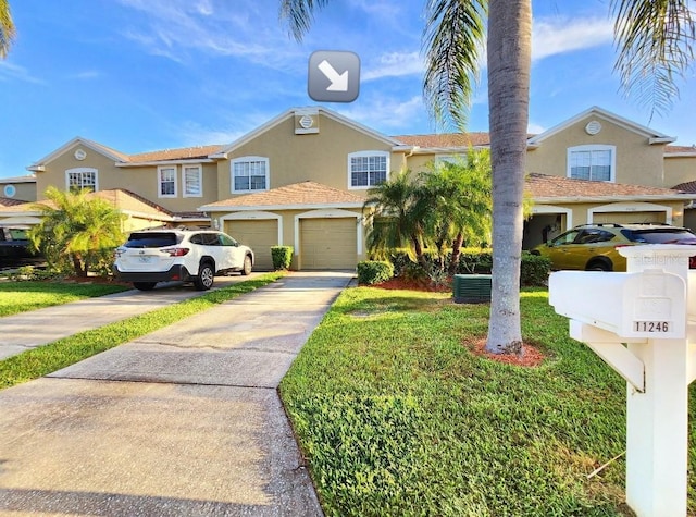 11246 Kapok Grand Cir, Madeira Beach, FL 33708 - view of front facade with concrete driveway, a garage, and stucco siding