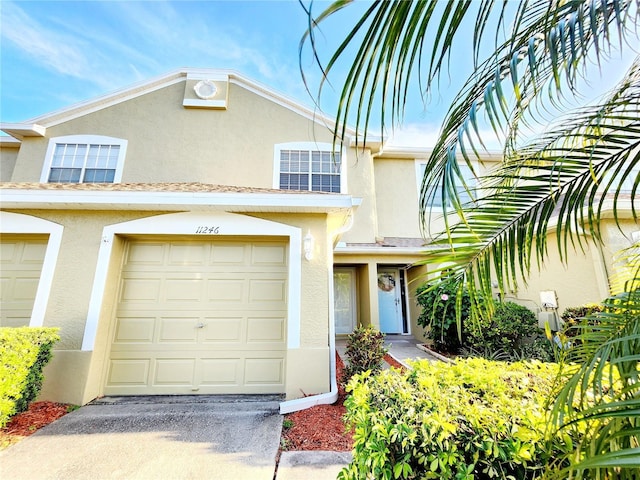 11246 Kapok Grand Cir, Madeira Beach, FL 33708 - townhome / multi-family property with stucco siding, a garage, and driveway