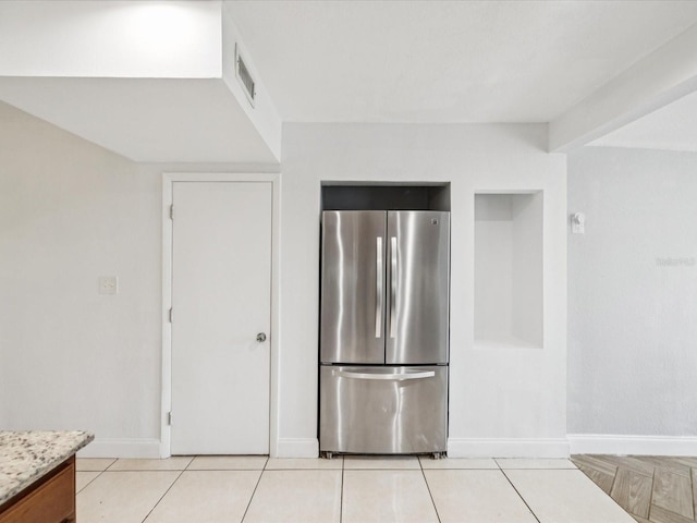 232 Emerald Ln, Largo, FL 33771 - kitchen featuring freestanding refrigerator, light tile patterned floors, and light stone countertops