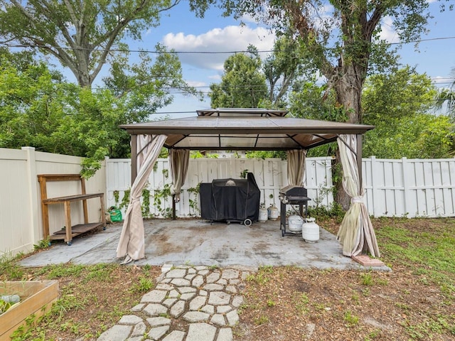 232 Emerald Ln, Largo, FL 33771 - fenced backyard featuring a gazebo, a patio, area for grilling, and a detached carport