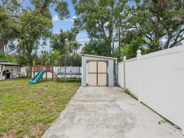 232 Emerald Ln, Largo, FL 33771 - fenced backyard featuring a playground and a storage unit
