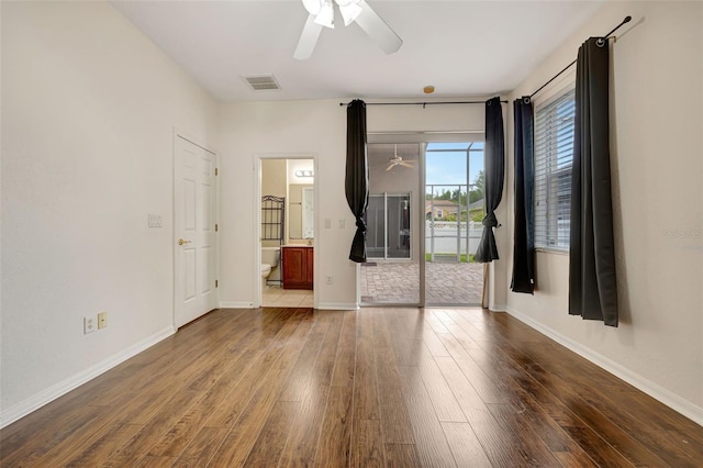 unfurnished room featuring baseboards, ceiling fan, wood finished floors, and visible vents