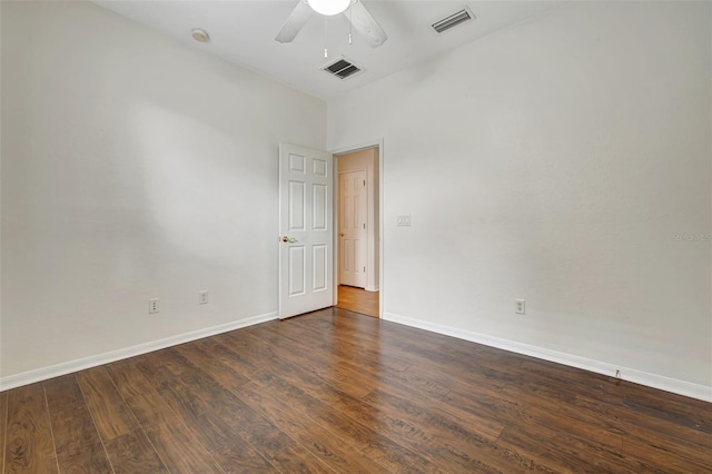 spare room with visible vents, baseboards, dark wood-type flooring, and ceiling fan