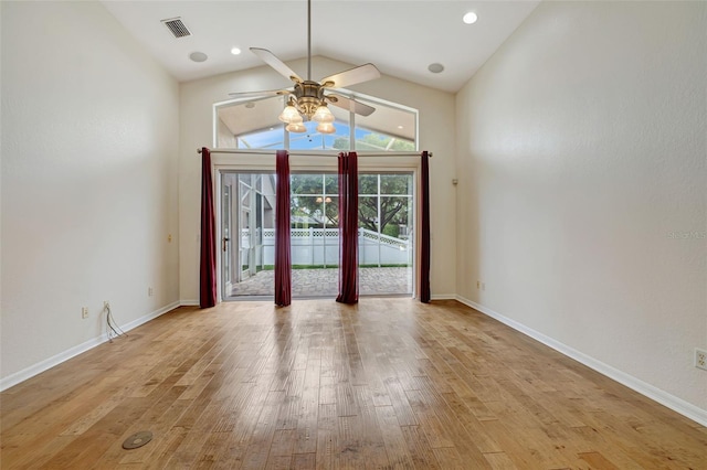 empty room featuring ceiling fan, baseboards, vaulted ceiling, light wood-type flooring, and visible vents