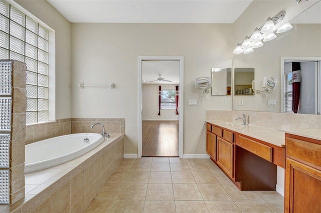 full bath with ceiling fan, tile patterned flooring, vanity, baseboards, and a bath