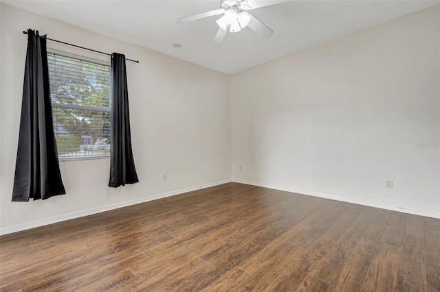 empty room featuring a ceiling fan, baseboards, and wood finished floors