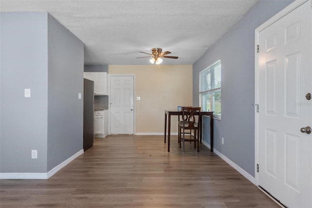 dining room featuring baseboards, wood finished floors, and ceiling fan