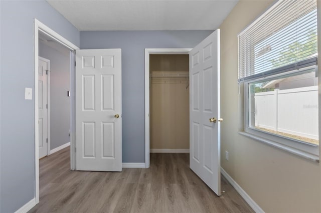 unfurnished bedroom with wood finished floors and baseboards