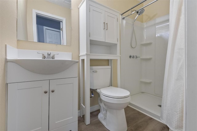 full bathroom featuring a shower stall, vanity, toilet, and wood finished floors