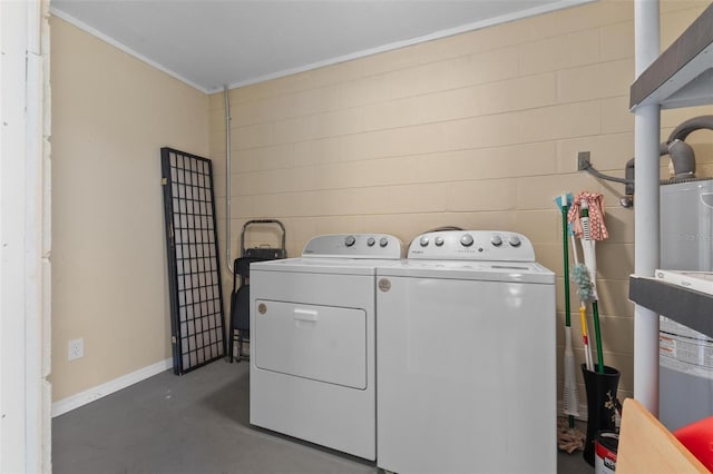 laundry area with laundry area, crown molding, washing machine and clothes dryer, concrete block wall, and baseboards