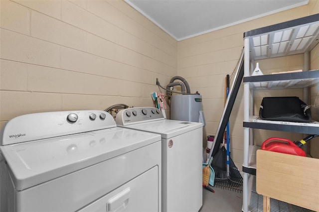 clothes washing area with electric water heater, independent washer and dryer, concrete block wall, and laundry area