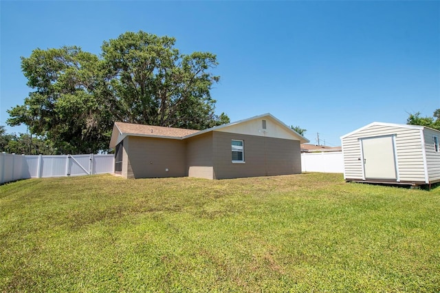 view of home's exterior with an outbuilding, a fenced backyard, a lawn, and a storage unit