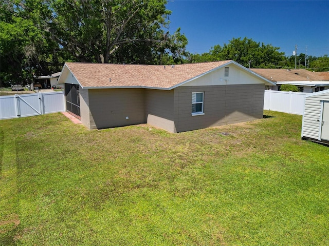view of home's exterior featuring a lawn, a fenced backyard, and a gate