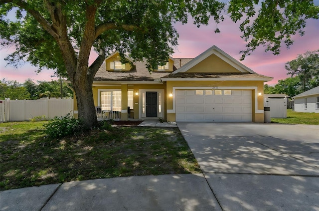 view of front facade featuring stucco siding, driveway, an attached garage, a porch, and fence